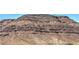 Rugged desert mountain with layered rock formations in a dry, sunny landscape at 6821 Prairie Pearl St, Las Vegas, NV 89148