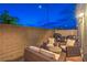 Outdoor patio area features stylish wicker furniture, a grill, and a dining set at dusk at 6821 Prairie Pearl St, Las Vegas, NV 89148