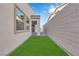 Backyard view showcasing artificial turf and a walkway leading to the covered patio at 720 Webber Park St, Henderson, NV 89011