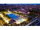 Aerial view of the community pool, clubhouse, and surrounding homes at twilight at 720 Webber Park St, Henderson, NV 89011