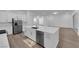 Open kitchen with a large island, stainless steel appliances, and wood flooring throughout the house at 720 Webber Park St, Henderson, NV 89011