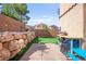 Well-kept backyard with a block wall, rock landscaping, and artificial turf at 7641 Lani Dawn St, Las Vegas, NV 89149