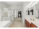 Bright bathroom featuring double sinks, tiled floors, and a glass-enclosed shower and tub at 7641 Lani Dawn St, Las Vegas, NV 89149