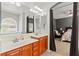 Bright bathroom featuring a double sink vanity with modern lighting and a glimpse into the main bedroom at 7641 Lani Dawn St, Las Vegas, NV 89149