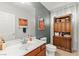 Well-lit bathroom featuring a vanity, toilet, and decorative cabinet with ample storage space at 7641 Lani Dawn St, Las Vegas, NV 89149