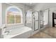 Bright bathroom featuring a large window, shower, and luxurious soaking tub for ultimate relaxation at 7641 Lani Dawn St, Las Vegas, NV 89149