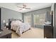 Bright bedroom with a ceiling fan, large windows, and a comfortable bed with floral bedding at 7641 Lani Dawn St, Las Vegas, NV 89149