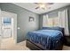Cozy bedroom with blue striped bedding and a ceiling fan with attached laundry room at 7641 Lani Dawn St, Las Vegas, NV 89149