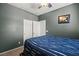 Comfortable bedroom featuring a blue striped bedspread, soft carpet, and a storage closet at 7641 Lani Dawn St, Las Vegas, NV 89149