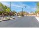 View of the iron gate and entry to a gated community with lush greenery and well-maintained landscaping at 7641 Lani Dawn St, Las Vegas, NV 89149