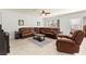 Comfortable living room with a large leather sectional sofa, ceiling fan, and neutral decor at 7641 Lani Dawn St, Las Vegas, NV 89149