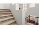 Carpeted staircase leading to the upper level with iron railing and natural light from windows at 7641 Lani Dawn St, Las Vegas, NV 89149