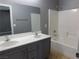 Modern bathroom with dual sinks, a large mirror, and shower-tub combination at 7924 Pale Rider St, Las Vegas, NV 89131