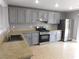 Well-lit kitchen features gray cabinets, tile floor, and stainless steel appliances at 7924 Pale Rider St, Las Vegas, NV 89131