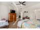 This airy bedroom features a ceiling fan, an ensuite bath with an open doorway and carpeted floors at 7927 Crested Starling Ct, North Las Vegas, NV 89084