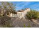 Side view of the home's exterior featuring desert landscaping, solar panels and patio at 7927 Crested Starling Ct, North Las Vegas, NV 89084