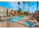 Community pool and hot tub, surrounded by lounge chairs and tall palm trees on a sunny day at 8101 W Flamingo Rd # 2006, Las Vegas, NV 89147