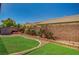 Well maintained backyard features manicured landscaping, lovely brick accents, and lush, green artificial turf at 8129 Jim Steele Falls St, North Las Vegas, NV 89085
