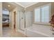 Bathroom featuring a glass shower, a soaking tub, and doorway leading to bedroom at 8129 Jim Steele Falls St, North Las Vegas, NV 89085
