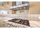 Close-up of a kitchen featuring a stainless steel range hood and a professional-grade gas cooktop at 8316 Broad Peak Dr, Las Vegas, NV 89131