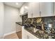 Modern laundry room with sleek cabinetry, black marbled countertop, and stylish gold faucet at 8316 Broad Peak Dr, Las Vegas, NV 89131