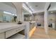 Bright bathroom with dual sinks, quartz countertops, and large arched mirrors at 9520 Sundial Dr, Las Vegas, NV 89134