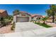 Single story home with desert landscaping, tile roof, artificial turf, and three car garage at 9520 Sundial Dr, Las Vegas, NV 89134