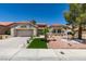 Single story home with desert landscaping, tile roof, artificial turf, and three car garage at 9520 Sundial Dr, Las Vegas, NV 89134