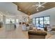 Spacious living room featuring vaulted wood ceiling, modern furniture, and large windows overlooking the backyard at 9520 Sundial Dr, Las Vegas, NV 89134