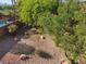 Backyard with a rock bed, various shrubs, a glimpse of a pool and mature trees at , Henderson, NV 89052