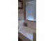 Bathroom featuring a built-in tub with tile surround and a window, white paint, and a towel rack at , Henderson, NV 89052