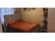 Comfortable bedroom with an upholstered headboard and a warm orange comforter. Features art and shelving at , Henderson, NV 89052