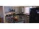 Updated kitchen with gray cabinets, stainless steel appliances, granite countertops, and a black refrigerator at , Henderson, NV 89052