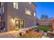 A backyard features a well-kept lawn, patio furniture, and sliding glass doors leading into the home at 10047 Alden Creek St, Las Vegas, NV 89141