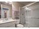 This bathroom features a white vanity and sink, toilet, and glass-enclosed shower, combining functionality with style at 10047 Alden Creek St, Las Vegas, NV 89141