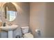 Well-lit half bathroom with a pedestal sink and a toilet, providing convenience for guests and residents at 10047 Alden Creek St, Las Vegas, NV 89141