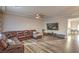 Spacious living room with hardwood floors, ceiling fan, and comfortable sectional sofa, great for relaxing and entertaining at 10047 Alden Creek St, Las Vegas, NV 89141