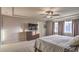 Spacious main bedroom featuring a tray ceiling, fan, dresser, and two windows at 10047 Alden Creek St, Las Vegas, NV 89141