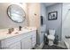 Well-lit bathroom with a vanity, framed round mirror, toilet, shower, and neutral color scheme at 1012 Greystone Dr, Las Vegas, NV 89108