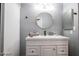 Well-lit bathroom featuring a white vanity with a lovely round mirror and gray wall paint at 1012 Greystone Dr, Las Vegas, NV 89108
