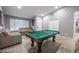 Bright game room featuring a pool table, neutral paint, ceiling fan, tile flooring, and comfortable seating at 1012 Greystone Dr, Las Vegas, NV 89108
