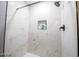 Walk-in shower with white marble-style walls, black fixtures, and built-in niche shelving at 1012 Greystone Dr, Las Vegas, NV 89108