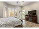 Cozy bedroom featuring wood floors, windows with shutters, and television at 10301 Bent Brook Pl, Las Vegas, NV 89134