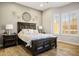 Bedroom featuring neutral colors, wood floors, large window and lamps on nightstands at 10301 Bent Brook Pl, Las Vegas, NV 89134