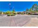 Elegant building entrance with circular driveway, mature landscaping, and decorative signage against a clear blue sky at 10301 Bent Brook Pl, Las Vegas, NV 89134