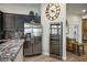 Modern kitchen features stainless steel refrigerator, wine cooler, and granite countertops at 10301 Bent Brook Pl, Las Vegas, NV 89134