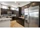 Contemporary kitchen with stainless steel appliances, dark cabinets, and granite countertops at 10301 Bent Brook Pl, Las Vegas, NV 89134