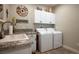 Functional laundry room with white cabinets, sink, and modern appliances at 10301 Bent Brook Pl, Las Vegas, NV 89134