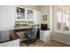 This home office features custom cabinetry, a built-in desk, and natural light from the shuttered window at 10301 Bent Brook Pl, Las Vegas, NV 89134