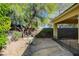 Backyard with mature desert landscaping, a gravel walkway, and a cozy, shaded area, perfect for outdoor relaxation at 10302 Cara Mia Ct, Las Vegas, NV 89135